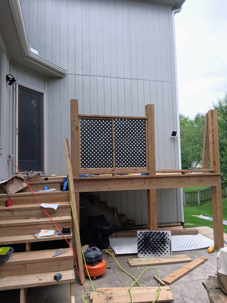 Elevated deck framing and privacy railing installation in progress