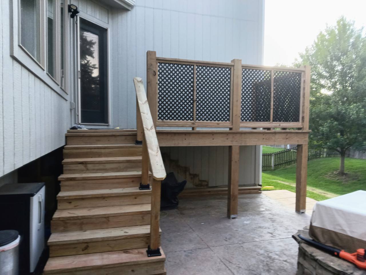 Completed wooden stairs and elevated deck viewed from the patio