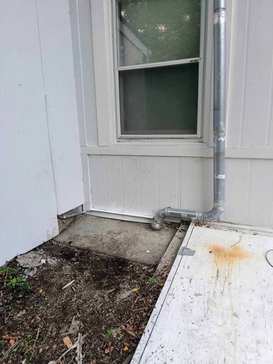 Completed lower window trim and siding beside the exterior downspout