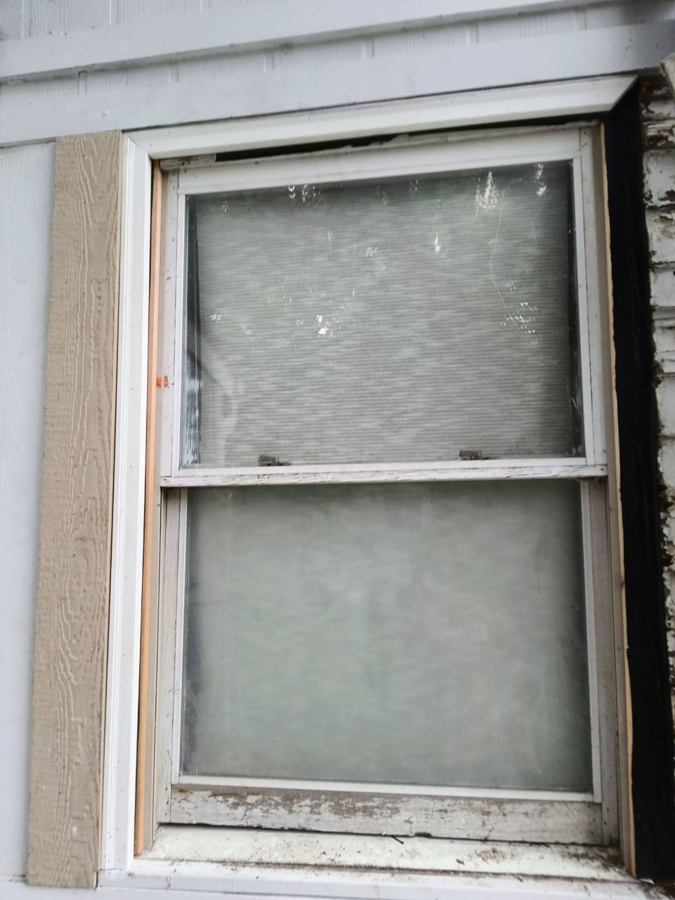 Exterior window trim nearing completion with final side still exposed